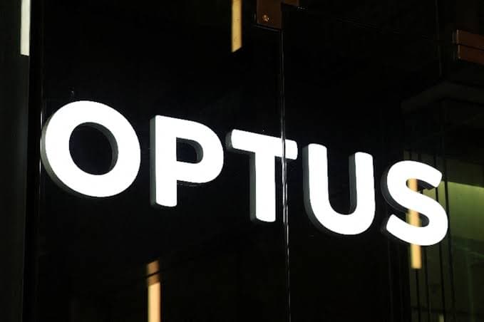Illuminated Optus sign on a building at night
